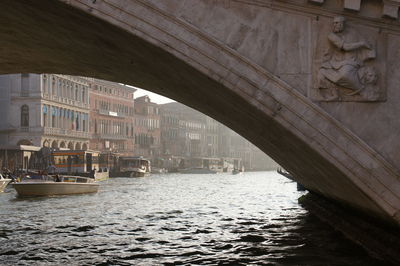 Bridge over river by buildings in city