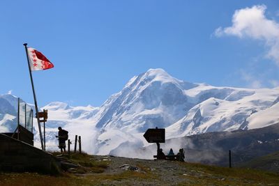 Scenic view of snowcapped mountains against blue sky