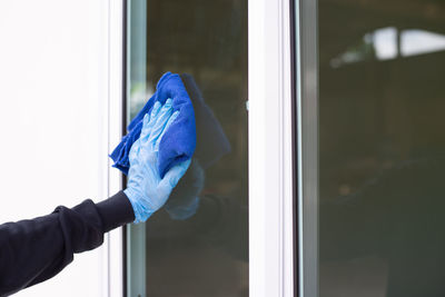 Cropped image of hand holding glass window