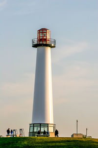 Low angle view of lighthouse on field against sky