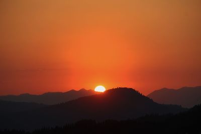 Scenic view of silhouette mountains against romantic sky at sunset