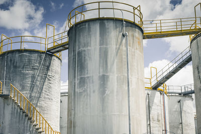 Low angle view of silos against sky