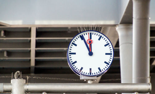 Low angle view of clock on metal