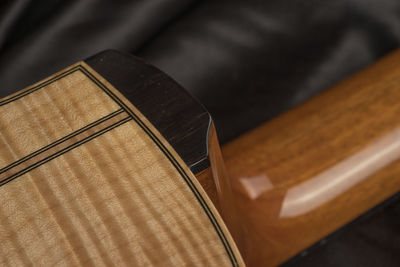 Cropped image of guitar on bed