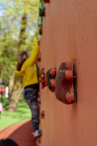 Midsection of woman with arms raised against wall