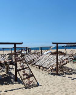 Low angle view of beach against clear blue sky