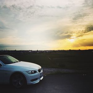 Car on road against sky during sunset