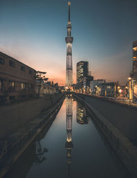 Illuminated buildings against sky during sunset