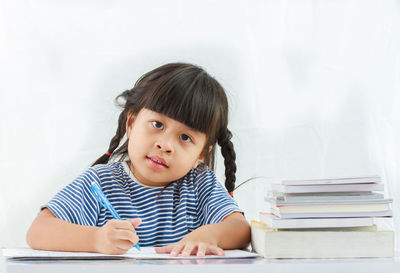 Portrait of girl sitting on table