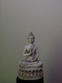 Statue of buddha against wall