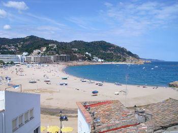 View of crowded beach against cloudy sky