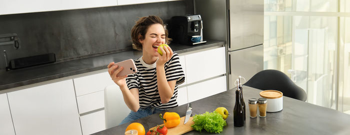 Young woman using mobile phone at home