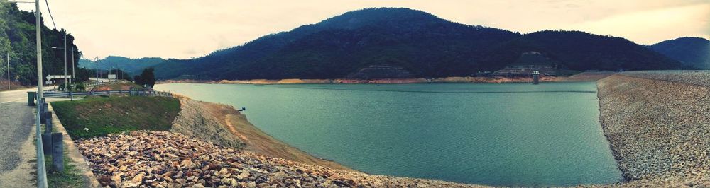 Scenic view of lake by mountains against sky