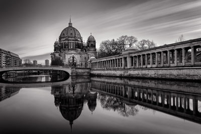 Reflection of church in river against sky