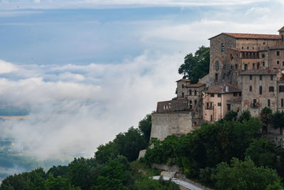 Buildings in city against cloudy sky