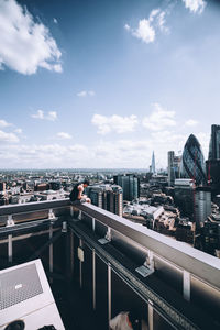 People on bridge against buildings in city