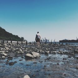 Full length of woman standing on rocks at beach