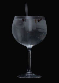 Close-up of wine glass against black background