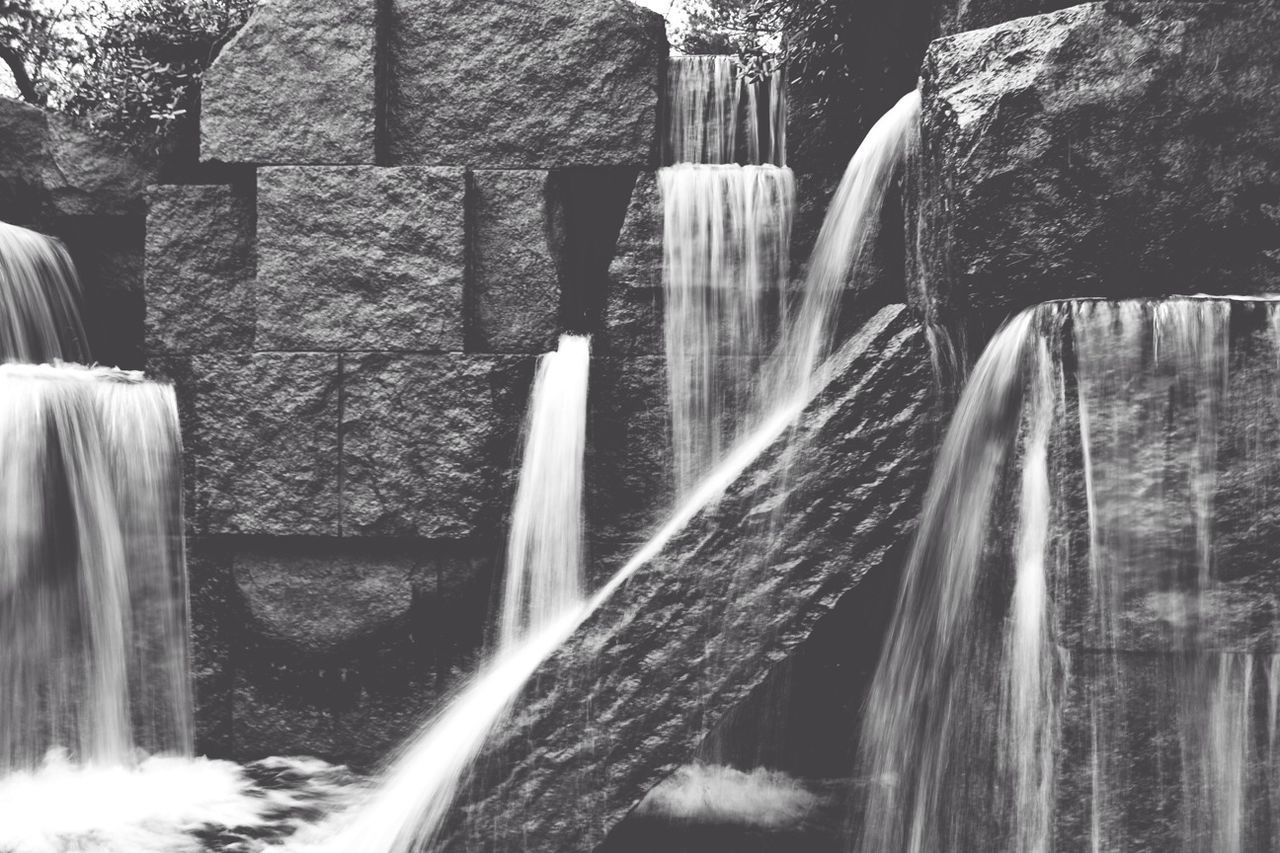 waterfall, motion, water, flowing water, flowing, long exposure, rock - object, splashing, blurred motion, nature, beauty in nature, rock formation, waterfront, day, fountain, outdoors, river, travel destinations, bridge - man made structure, built structure