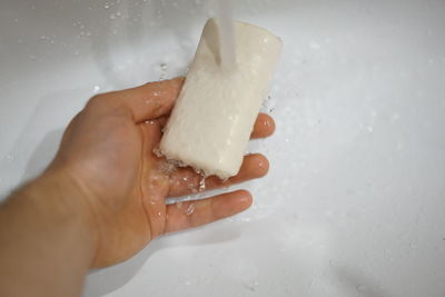 Close-up of hand holding leaf in bathroom