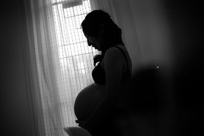 Side view of woman looking at window