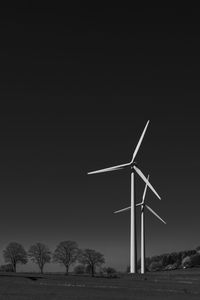 Low angle view of windmills against clear sky