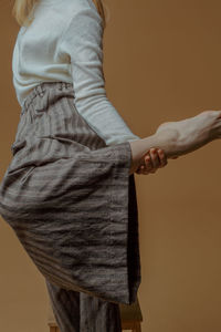 Low section of woman standing against white background