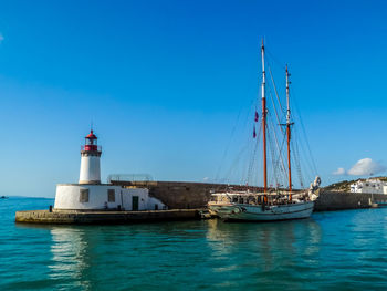 Sailboats sailing in sea against clear blue sky