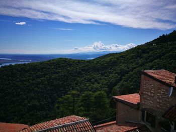 Houses on mountain against sky