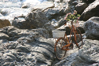 Rusty bicycle abandoned on rocky shore