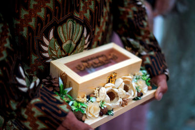 Cropped hand of a man holding wedding gift box 