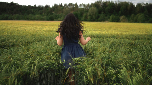 Rear view of woman standing in field