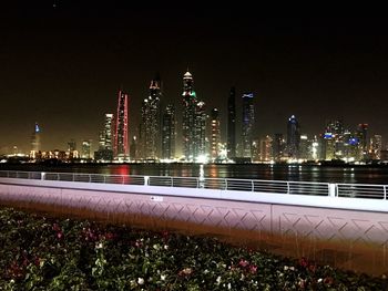 Illuminated cityscape against sky at night