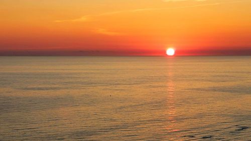 Scenic view of sea against romantic sky at sunset