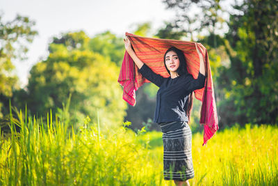 Young woman wearing shawl amidst grassy field