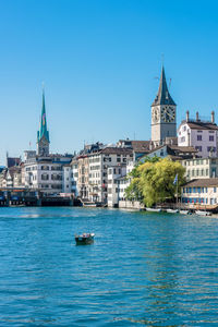 View of buildings in city against clear blue sky