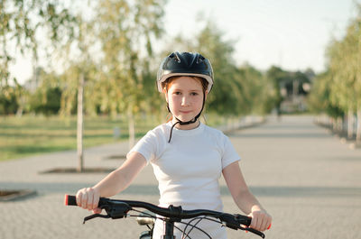 Teenage girl in a helmet on a bicycle. red-haired girl