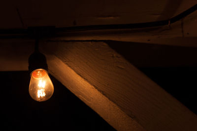 Low angle view of illuminated pendant lights hanging on ceiling