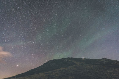 Scenic view of mountains against sky at night