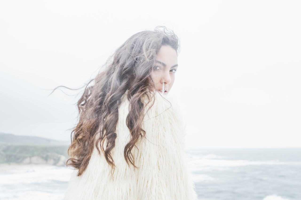 young adult, young women, long hair, lifestyles, person, clear sky, leisure activity, sea, beach, portrait, headshot, front view, side view, standing, water, waist up, looking at camera