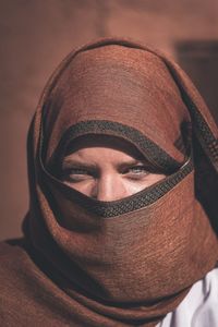 Close-up portrait of woman with face covered by scarf