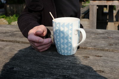 Man holding coffee cup on table