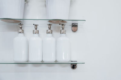 Close-up of soap dispensers on shelves