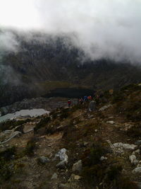 People walking on mountain against sky