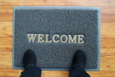 Low section of person standing by text on floor