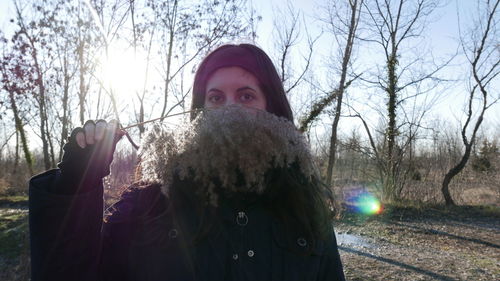 Portrait of man against bare trees in winter