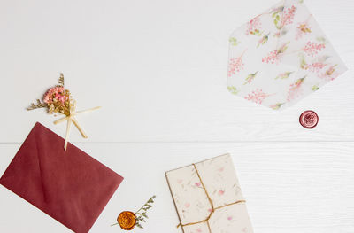 Vintage letters with flowers over the white wooden background.