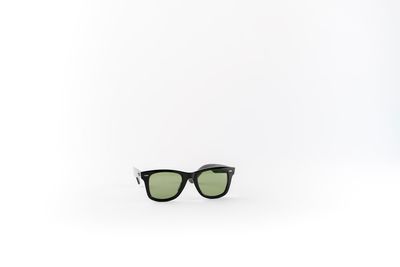 Close-up of sunglasses on glass against white background