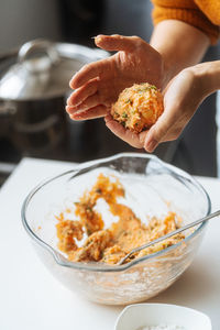 Crop hands of housewife preparing healthy meatless cutlets with homemade stuffing made from salmon and potato