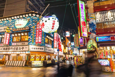 Graffiti on illuminated street amidst buildings in city at night